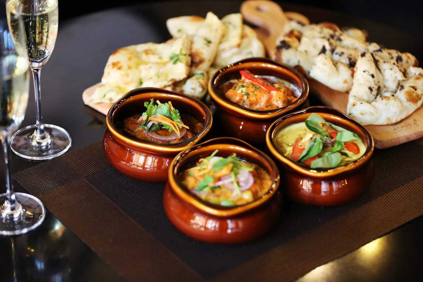 A row of curry pots beside champagne coupes